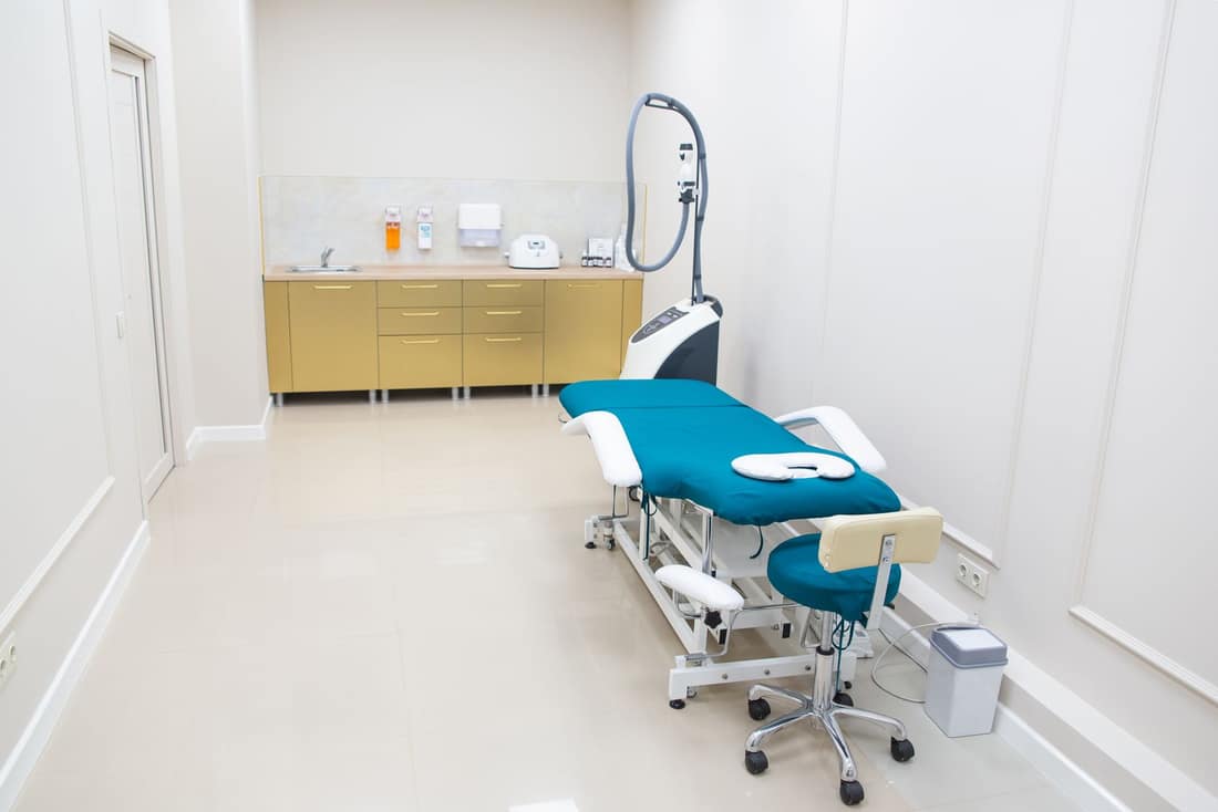 Helles Behandlungszimmer mit Liege und Hocker